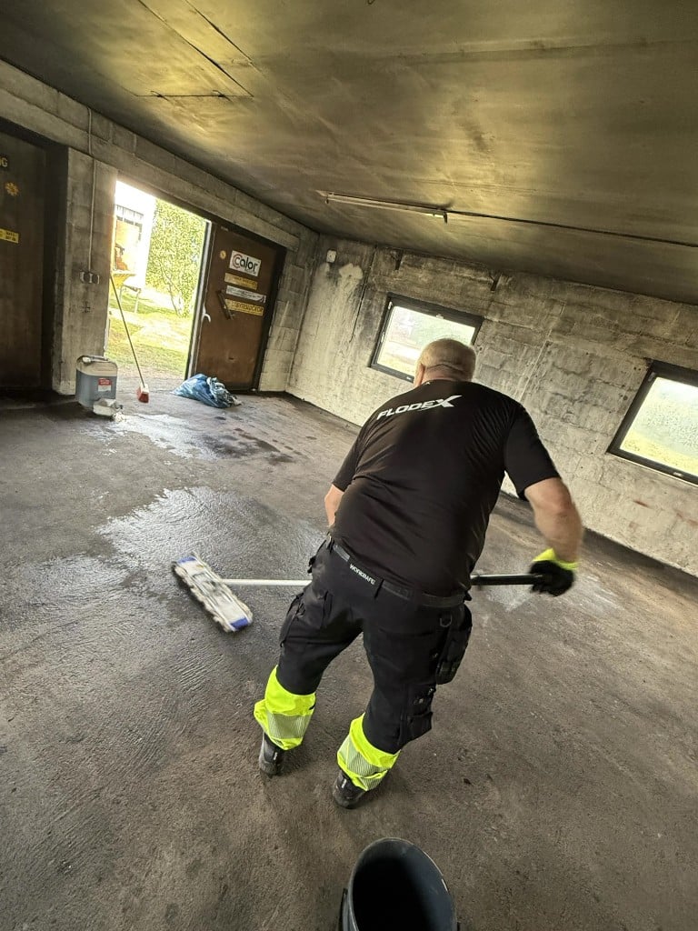 Flodex brandsanerar efter brand - moppar sot från betonggolv i Skåne